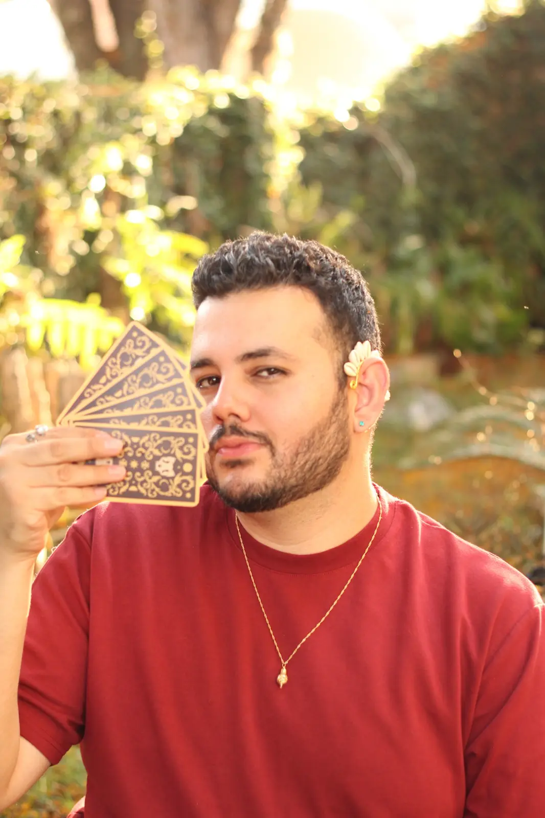 Àlison Simeão segurando cartas em um jardim